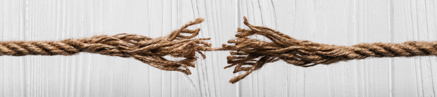 Rope frayed about to break on Wooden white background