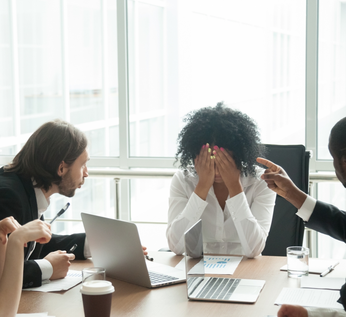 Rude diverse colleagues humiliating offending stressed upset young african woman leader suffering from gender racial discrimination during meeting or feeling exhausted tired of responsibility at work